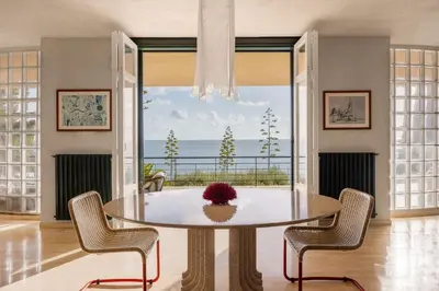 a dining room with a table and chairs and a window at villa Capo Zafferano in Bagheria