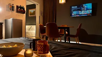 a living room with a table and chairs and a television at SILVIO'S Apartment in Castellammare del Golfo