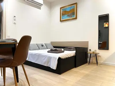 a bedroom with a bed and a table and a chair at SILVIO'S Apartment in Castellammare del Golfo