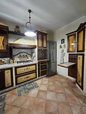 a kitchen with wooden cabinets and a stainless steel refrigerator at La Casa Di Ady in Palermo