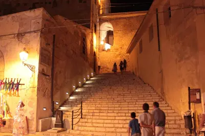 a group of people walking up some stairs at night at Bovio guest House in Castellammare del Golfo