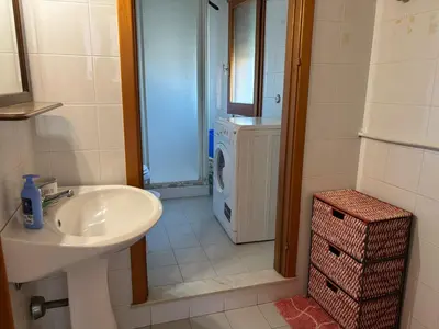 a bathroom with a sink and a washing machine at Appartamento Vista Golfo in Castellammare del Golfo