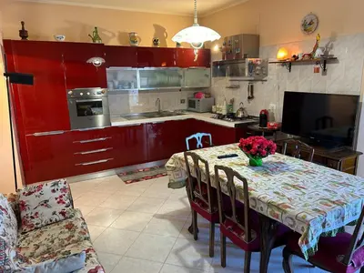 a kitchen with a table with flowers on it at Appartamento Vista Golfo in Castellammare del Golfo