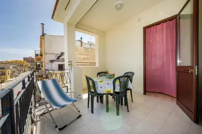 a dining room with a table and chairs on a balcony at Appartamento vista mare in Castellammare del Golfo