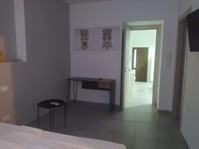 a room with a desk and a table and a door at Dai Mori in Lascari