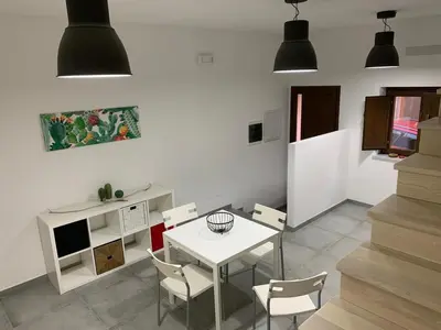 a dining room with a white table and chairs at Dai Mori in Lascari