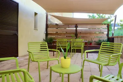 a group of green chairs and tables in a patio at Casale Morillo in Campofelice di Roccella
