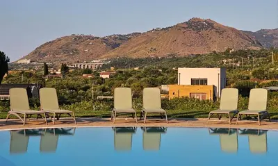 a group of chairs sitting next to a swimming pool at Casale Morillo in Campofelice di Roccella