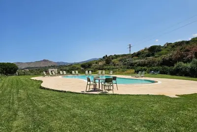 a table and chairs in front of a swimming pool at Casale Morillo in Campofelice di Roccella