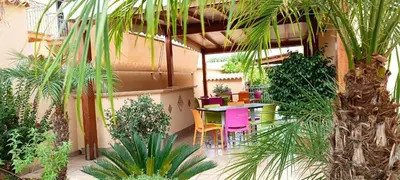 a patio with a table and chairs and plants at Le Falesie di Castelluzzo in Castelluzzo