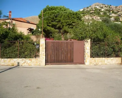 a gate in a stone wall with a wooden door at Villa Soliva - Mare e Panorama Unico in Mondello