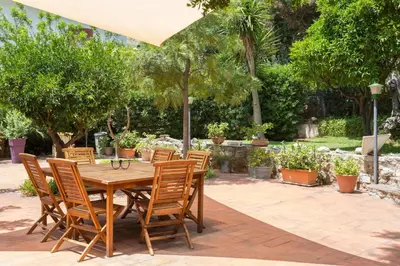 a wooden table and chairs on a patio at Villa Soliva - Mare e Panorama Unico in Mondello