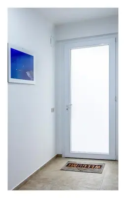 a door in a room with a picture on the wall at Battigia SOLEMAR-Alcamo Marina in Alcamo Marina