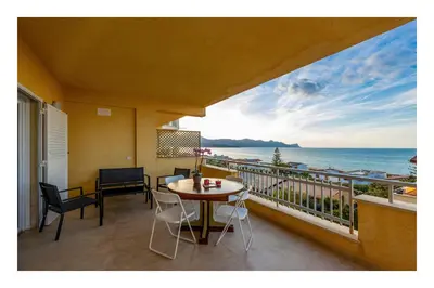 a balcony with a table and chairs and the ocean at Battigia SOLEMAR-Alcamo Marina in Alcamo Marina