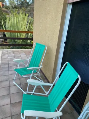two green lawn chairs sitting on a porch at Scopello Beach in Scopello