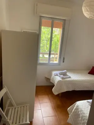 a small room with two beds and a window at Scopello Beach in Scopello