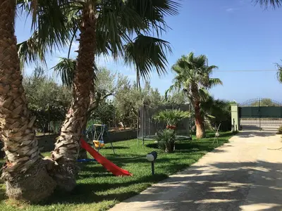 a palm tree with a hammock between two palm trees at Villa with private pool and wonderful view in Carini
