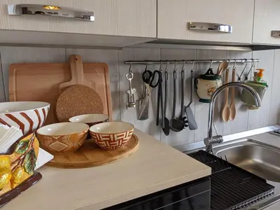 a kitchen counter with bowls and utensils and a sink at Villa with private pool and wonderful view in Carini