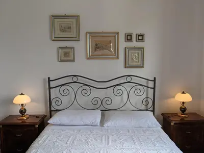 a bedroom with a bed with two nightstands and two lamps at Villa with private pool and wonderful view in Carini