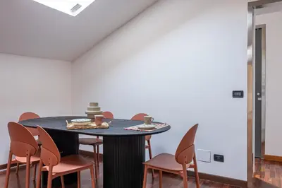 a dining room with a black table and chairs at Kadì Apartment by Wonderful Italy in Palermo