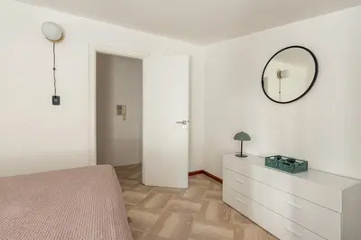 a white bedroom with a dresser and a mirror at Kadì Apartment by Wonderful Italy in Palermo