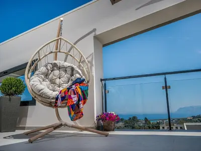 a swinging chair in front of a house with a window at Apartment Attico Dolce Vista by Interhome in Castellammare del Golfo