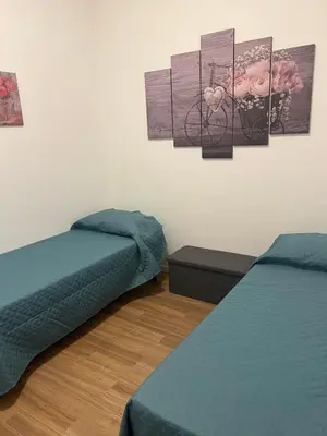 a room with two beds and paintings on the wall at GFL Mondello - Appartamenti vista mare in Mondello