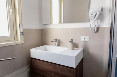 a bathroom with a white sink and a mirror at GFL Mondello - Appartamenti vista mare in Mondello