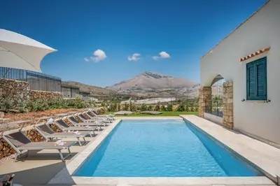 a swimming pool with lounge chairs next to a building at Villa Hemèra Luxury By Sicily Home Solutions in Castellammare del Golfo