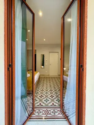 a room with a large glass door with a bedroom at Renda36 in Carini