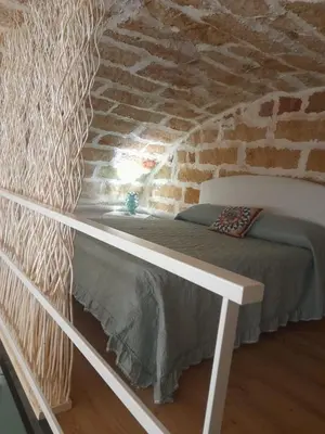 a bed in a room with a brick wall at Relaxing Room in Terrasini