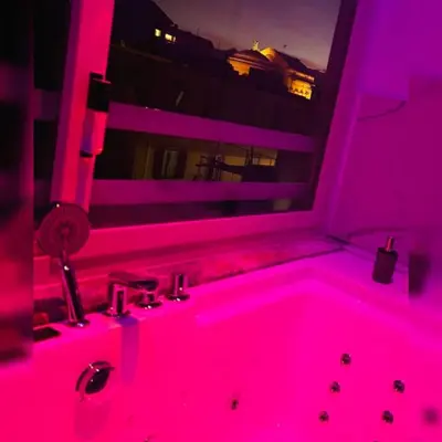 a pink bathroom with a tub with a window at Florio Suite Apartment in Palermo