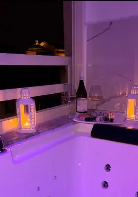 a bath tub with a bottle of wine and glasses at Florio Suite Apartment in Palermo