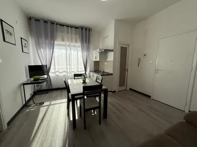a living room with a dining room table and a kitchen at Florio Suite Apartment in Palermo