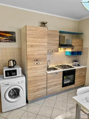 a kitchen with a stove and a washing machine at Onda Blu Apartment in Balestrate