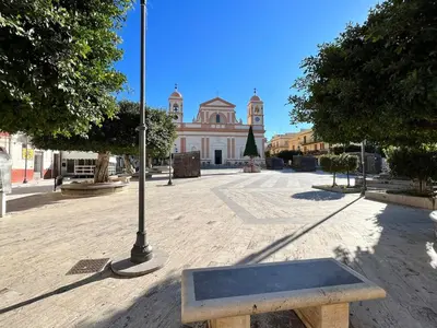 a bench in front of a building with a street light at Onda Blu Apartment in Balestrate
