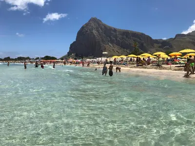 a group of people in the water at a beach at euforbia in San Vito lo Capo