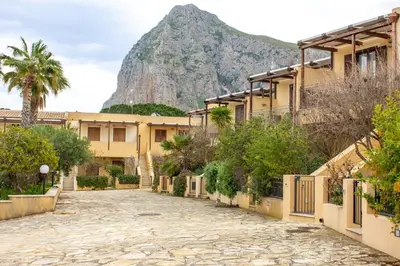 a street with a mountain in the background at euforbia in San Vito lo Capo