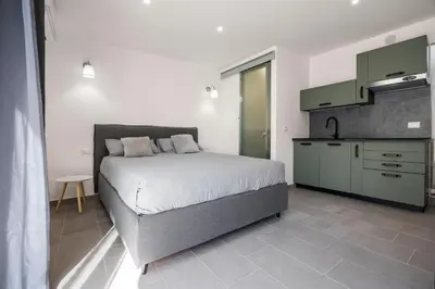 a bedroom with a large bed and a kitchen at Dream Holidays - Apartments in Palermo