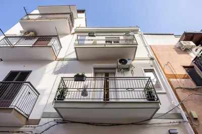 a tall white building with balconies on it at Dream Holidays - Apartments in Palermo
