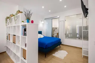 a bedroom with a blue bed and a book shelf at Dream Holidays - Apartments in Palermo