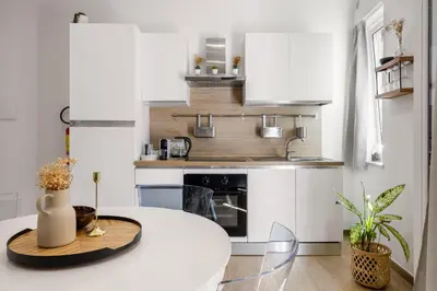 a white kitchen with a white table in a room at Dream Holidays - Apartments in Palermo