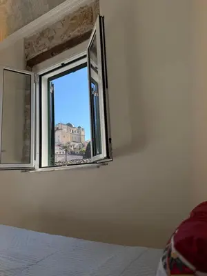 a bedroom with a window with a view of a building at La Piccola Formica in Palermo