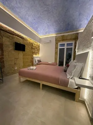 a bedroom with a large bed with a ceiling at La Piccola Formica in Palermo