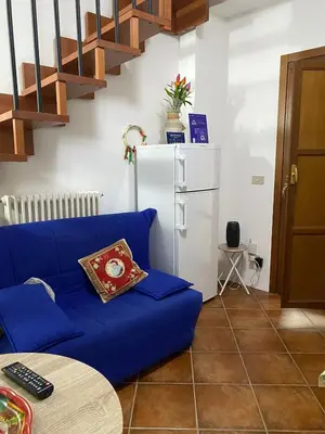 a living room with a blue couch and a refrigerator at Nonno Antonio's House in Palermo