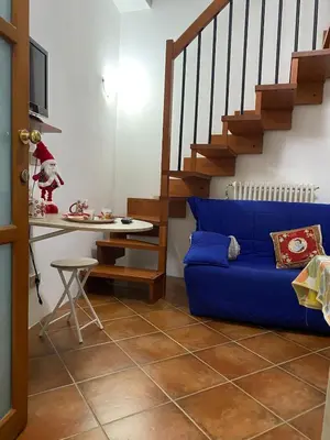a living room with a blue couch and stairs at Nonno Antonio's House in Palermo