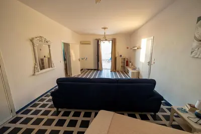 a living room with a black couch and a tile floor at Baia Marina Oasi in Balestrate