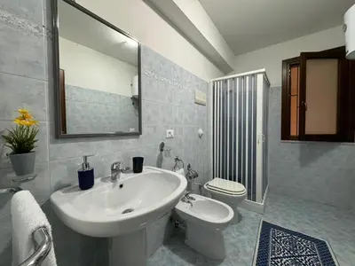 a bathroom with a sink and a toilet and a mirror at Maribu in Casteldaccia