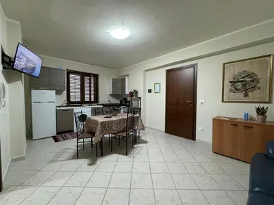 a kitchen and dining room with a table and chairs at Maribu in Casteldaccia