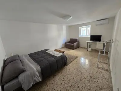 a bedroom with a bed and a chair and a desk at Mak house in Palermo